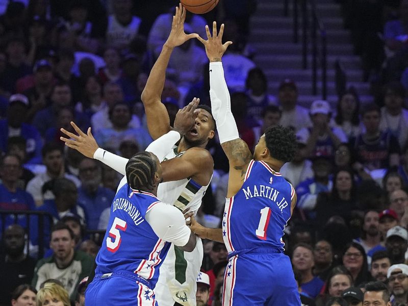 PHILADELPHIA, PENNSYLVANIA - OCTOBER 23: Giannis Antetokounmpo #34 of the Milwaukee Bucks passes the ball against Andre Drummond #5 and KJ Martin #1 of the Philadelphia 76ers in the first half at the Wells Fargo Center on October 23, 2024 in Philadelphia, Pennsylvania. NOTE TO USER: User expressly acknowledges and agrees that, by downloading and/or using this photograph, user is consenting to the terms and conditions of the Getty Images License Agreement. (Photo by Mitchell Leff/Getty Images)