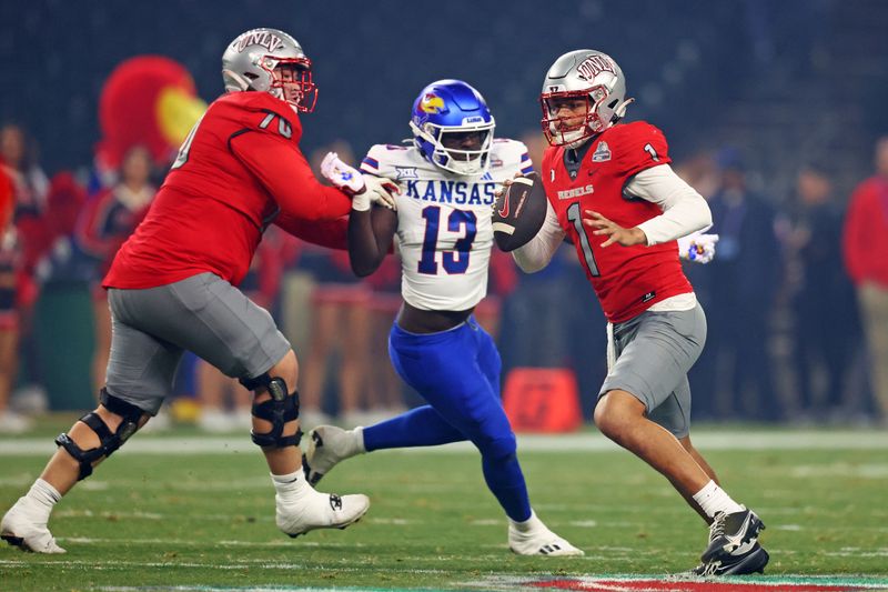 Dec 26, 2023; Phoenix, AZ, USA; UNLV Rebels quarterback Jayden Maiava (1) avoids the pressure of Kansas Jayhawks defensive end Dylan Brooks (13) during the first quarter in the Guaranteed Rate Bowl at Chase Field. Mandatory Credit: Mark J. Rebilas-USA TODAY Sports