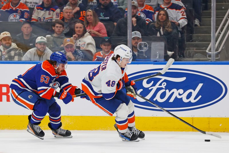 Jan 15, 2026; Edmonton, Alberta, CAN; New York Islanders defensemen Matthew Schaefer (48) protects the puck from from Edmonton Oilers forward Issac Howard (53) during the first period at Rogers Place. Mandatory Credit: Perry Nelson-Imagn Images
