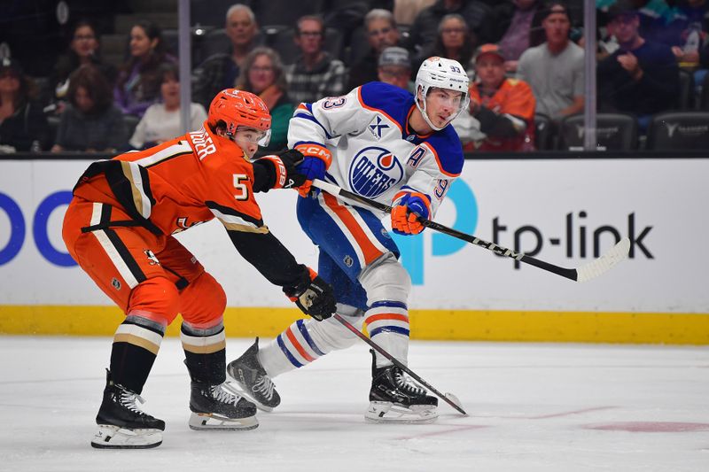 Apr 7, 2025; Anaheim, California, USA; Edmonton Oilers center Ryan Nugent-Hopkins (93) shoots against Anaheim Ducks defenseman Olen Zellweger (51) during the first period at Honda Center. Mandatory Credit: Gary A. Vasquez-Imagn Images