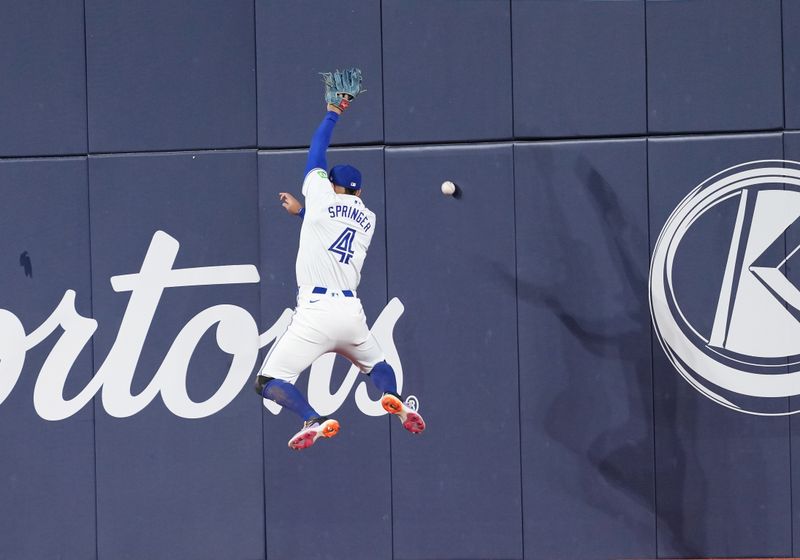 Jun 30, 2024; Toronto, Ontario, CAN; Toronto Blue Jays right fielder George Springer (4) tries to catch a fly ball  against the New York Yankees during the fifth inning at Rogers Centre. Mandatory Credit: Nick Turchiaro-USA TODAY Sports