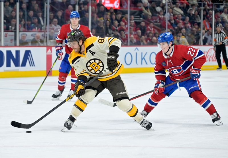 Mar 14, 2024; Montreal, Quebec, CAN; Boston Bruins forward David Pastrnak (88) plays the puck and Montreal Canadiens forward Cole Caufield (22) defends during the third period at the Bell Centre. Mandatory Credit: Eric Bolte-USA TODAY Sports