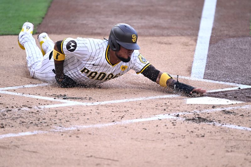 Jul 6, 2024; San Diego, California, USA; San Diego Padres second baseman Luis Arraez (4) slides home to score a run on a single hit by third baseman Manny Machado (not pictured) during the first inning against the Arizona Diamondbacks at Petco Park. Mandatory Credit: Orlando Ramirez-USA TODAY Sports