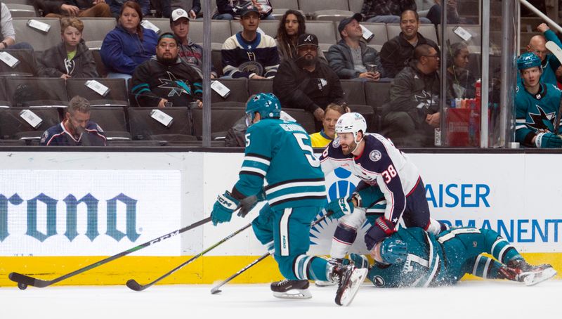 Mar 14, 2023; San Jose, California, USA; Columbus Blue Jackets center Boone Jenner (38) takes down San Jose Sharks center Nico Sturm (7) while pursuing the puck with Sharks defenseman Matt Benning (5) during the first period at SAP Center at San Jose. Mandatory Credit: D. Ross Cameron-USA TODAY Sports