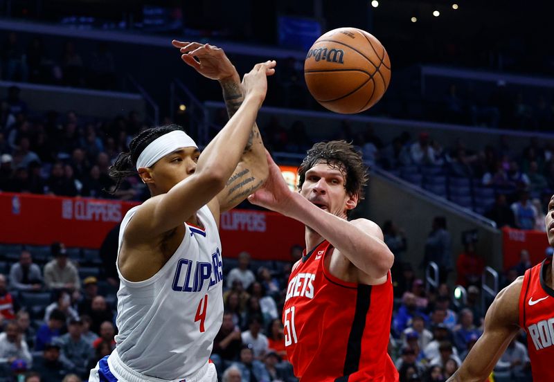 LOS ANGELES, CALIFORNIA - APRIL 14: Brandon Boston Jr. #4 of the LA Clippers passes the ball against Boban Marjanovic #51 of the Houston Rockets in the second half at Crypto.com Arena on April 14, 2024 in Los Angeles, California.  NOTE TO USER: User expressly acknowledges and agrees that, by downloading and/or using this photograph, user is consenting to the terms and conditions of the Getty Images License Agreement.  (Photo by Ronald Martinez/Getty Images)