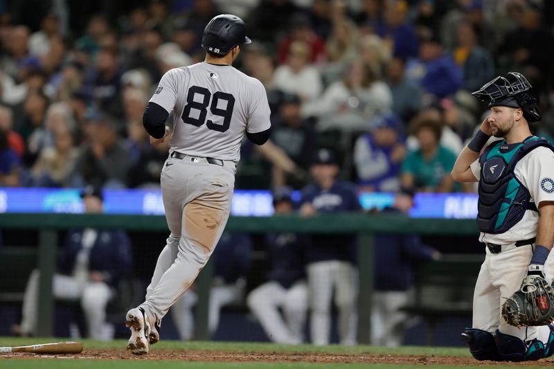 Sep 18, 2024; Seattle, Washington, USA; New York Yankees center fielder Jasson Domínguez (89) scores with Seattle Mariners catcher Cal Raleigh (29) watching during the 10th inning at T-Mobile Park. Mandatory Credit: John Froschauer-Imagn Images