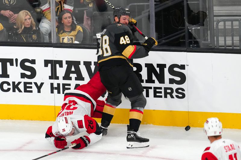 Oct 20, 2025; Las Vegas, Nevada, USA; Vegas Golden Knights center Tomas Hertl (48) checks Carolina Hurricanes defenseman Sean Walker (26) during the second period at T-Mobile Arena. Mandatory Credit: Stephen R. Sylvanie-Imagn Images