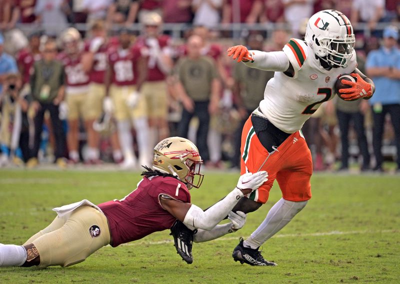 Nov 11, 2023; Tallahassee, Florida, USA; Miami Hurricanes running back Donald Chaney Jr. (2) is tackled by Florida State Seminoles defensive back Akeem Dent (1) at Doak S. Campbell Stadium. Mandatory Credit: Melina Myers-USA TODAY Sports