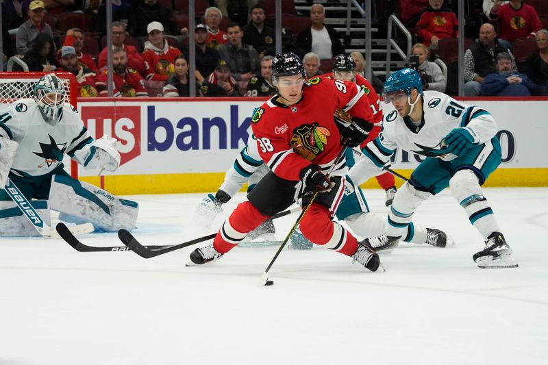 Oct 17, 2024; Chicago, Illinois, USA; San Jose Sharks center Alexander Wennberg (21) defends Chicago Blackhawks center Connor Bedard (98) during the third period at United Center. Mandatory Credit: David Banks-Imagn Images