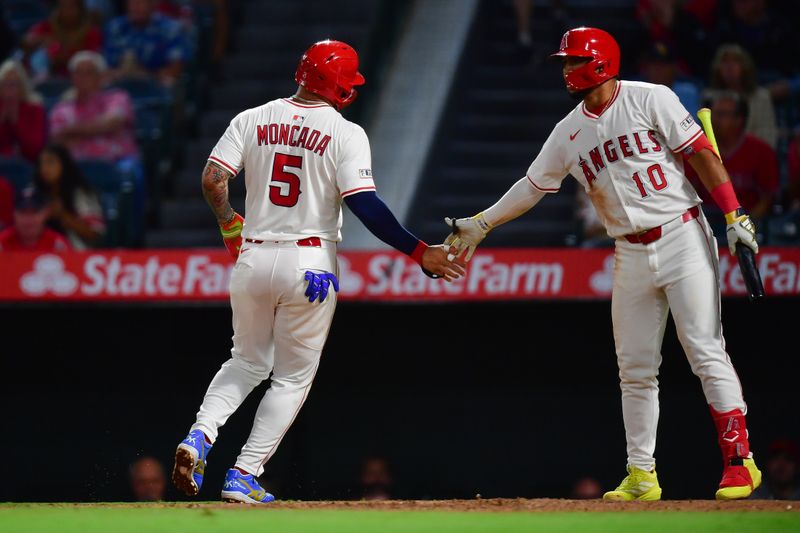Sep 9, 2025; Anaheim, California, USA; Los Angeles Angels third baseman Yoán Moncada (5) is greeted by first baseman Oswald Peraza (10) after scoring a run against the Minnesota Twins during the fifth inning at Angel Stadium. Mandatory Credit: Gary A. Vasquez-Imagn Images