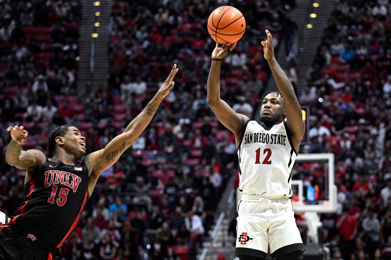 Jan 6, 2024; San Diego, California, USA; San Diego State Aztecs guard Darrion Trammell (12) shoots the ball over UNLV Rebels guard Luis Rodriguez (15) during the second half at Viejas Arena. Mandatory Credit: Orlando Ramirez-USA TODAY Sports