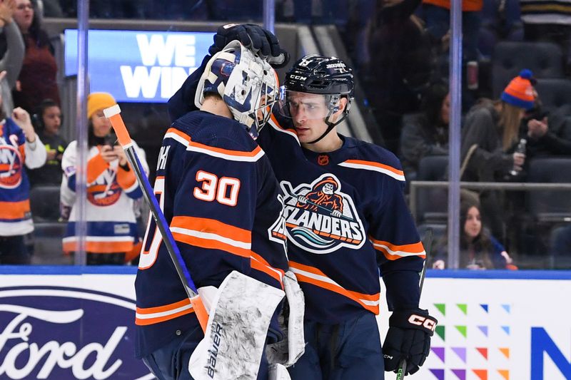 Dec 23, 2022; Elmont, New York, USA; New York Islanders center Mathew Barzal (13) celebrates the 5-1 victory with New York Islanders goaltender Ilya Sorokin (30) against the Florida Panthers during the third period at UBS Arena. Mandatory Credit: Dennis Schneidler-USA TODAY Sports