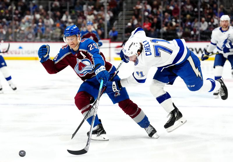 Nov 27, 2023; Denver, Colorado, USA; Tampa Bay Lightning center Anthony Cirelli (71) pokes the puck away from Colorado Avalanche center Nathan MacKinnon (29) in the second period at Ball Arena. Mandatory Credit: Ron Chenoy-USA TODAY Sports