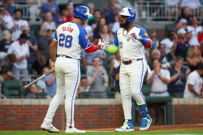 Aug 3, 2024; Atlanta, Georgia, USA; Atlanta Braves designated hitter Marcell Ozuna (20) celebrates with first baseman Matt Olson (28) after a home run against the Miami Marlins in the third inning at Truist Park. Mandatory Credit: Brett Davis-USA TODAY Sports
