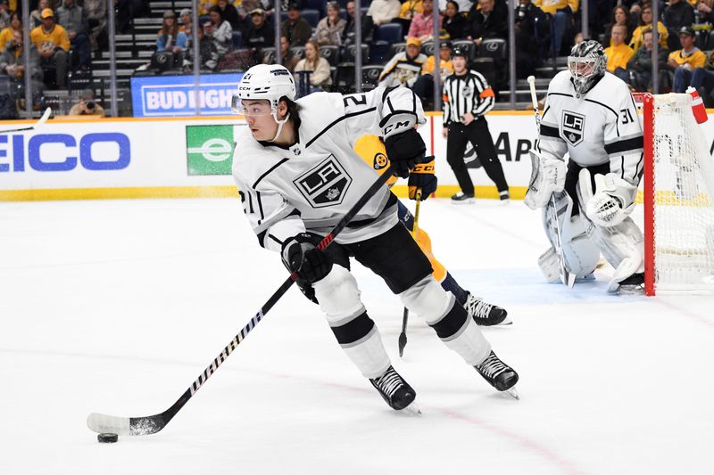 Jan 31, 2024; Nashville, Tennessee, USA; Los Angeles Kings defenseman Jordan Spence (21) handles the puck out of the defensive zone during the first period against the Nashville Predators at Bridgestone Arena. Mandatory Credit: Christopher Hanewinckel-USA TODAY Sports