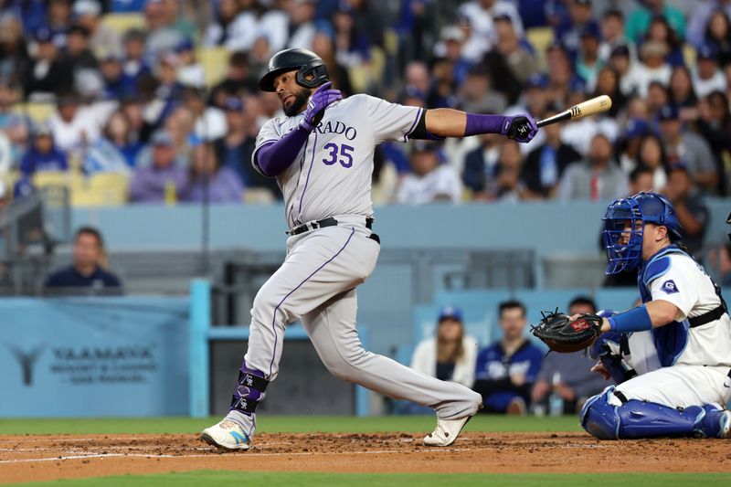 Jun 1, 2024; Los Angeles, California, USA;  Colorado Rockies catcher Elias Diaz (35) hits a single during the third inning against the Los Angeles Dodgers at Dodger Stadium. Mandatory Credit: Kiyoshi Mio-USA TODAY Sports