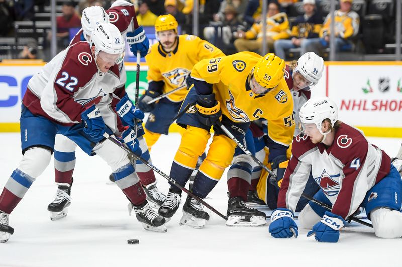 Nov 20, 2023; Nashville, Tennessee, USA; Colorado Avalanche center Fredrik Olofsson (22) clears the puck against the Nashville Predators during the first period at Bridgestone Arena. Mandatory Credit: Steve Roberts-USA TODAY Sports