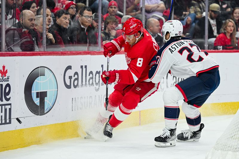 Feb 27, 2025; Detroit, Michigan, USA; Columbus Blue Jackets center Zachary Aston-Reese (27) checks Detroit Red Wings defenseman Ben Chiarot (8) during the first period at Little Caesars Arena. Mandatory Credit: Tim Fuller-Imagn Images