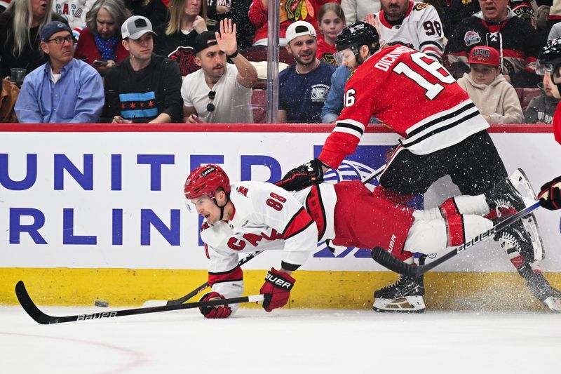 Apr 14, 2024; Chicago, Illinois, USA; Carolina Hurricanes forward Martin Necas (88) is checked off the puck in the first period by Chicago Blackhawks forward Jason Dickinson (16) at United Center. Mandatory Credit: Jamie Sabau-USA TODAY Sports