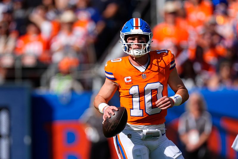 Denver Broncos quarterback Bo Nix looks downfield during the first half of an NFL football game against the Las Vegas Raiders, Sunday, Oct. 6, 2024, in Denver. (AP Photo/David Zalubowski)