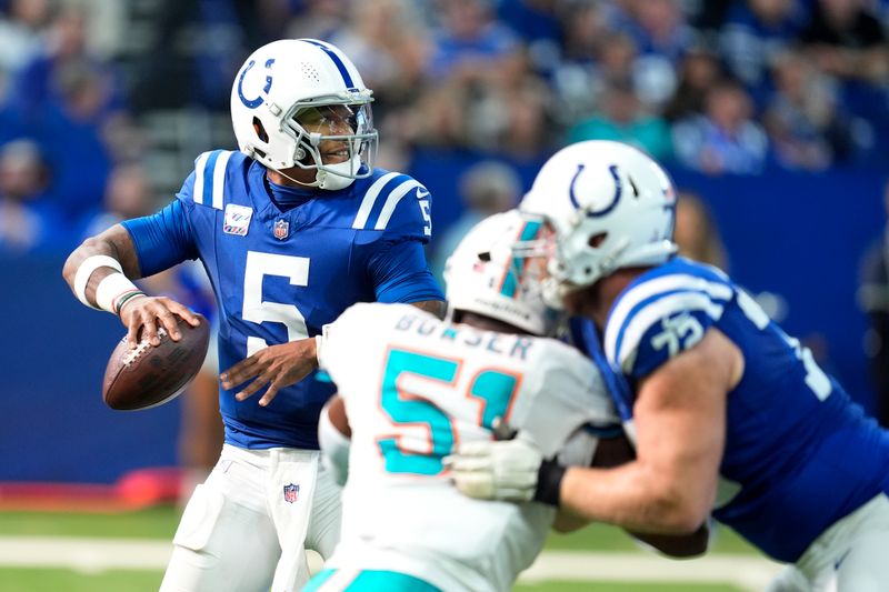 Indianapolis Colts quarterback Anthony Richardson (5) passes under pressure from Miami Dolphins linebacker Tyus Bowser (51) during the second half of an NFL football game, Sunday, Oct. 20, 2024 in Indianapolis. (AP Photo/Michael Conroy)