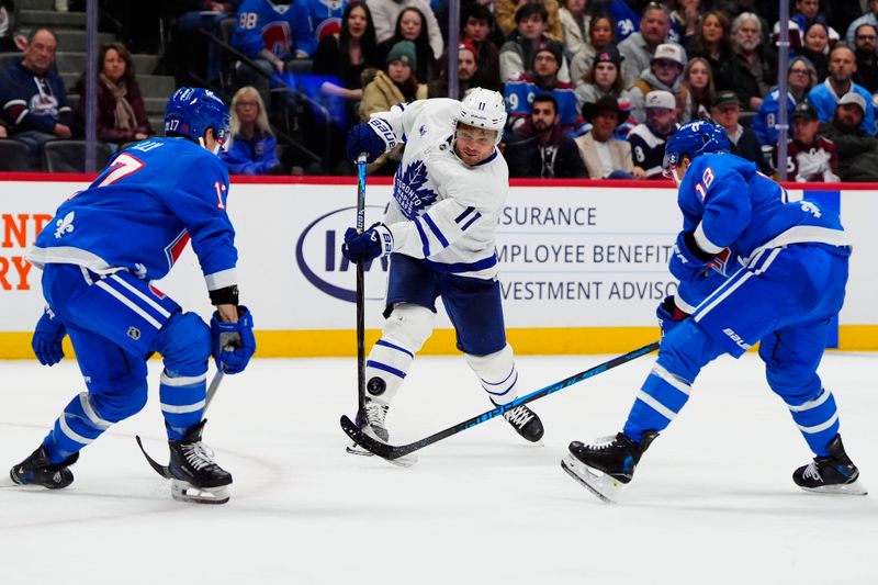 Jan 12, 2026; Denver, Colorado, USA; Toronto Maple Leafs center Max Domi (11) takes a shot on the net of the Colorado Avalanche in the third period at Ball Arena. Mandatory Credit: Ron Chenoy-Imagn Images