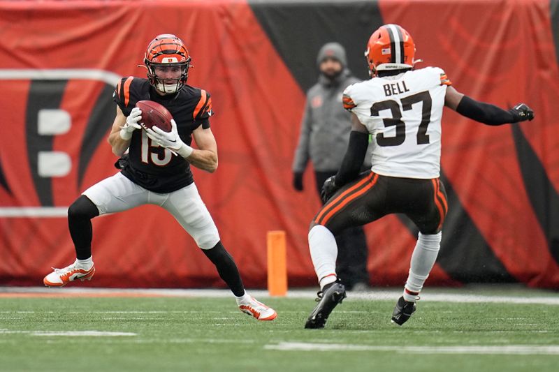 Cincinnati Bengals wide receiver Charlie Jones (15) catches a punt in front of Cleveland Browns safety D'Anthony Bell (37) in the first half of an NFL football game, Sunday, Jan. 7, 2024, in Cincinnati. (AP Photo/Sue Ogrocki)