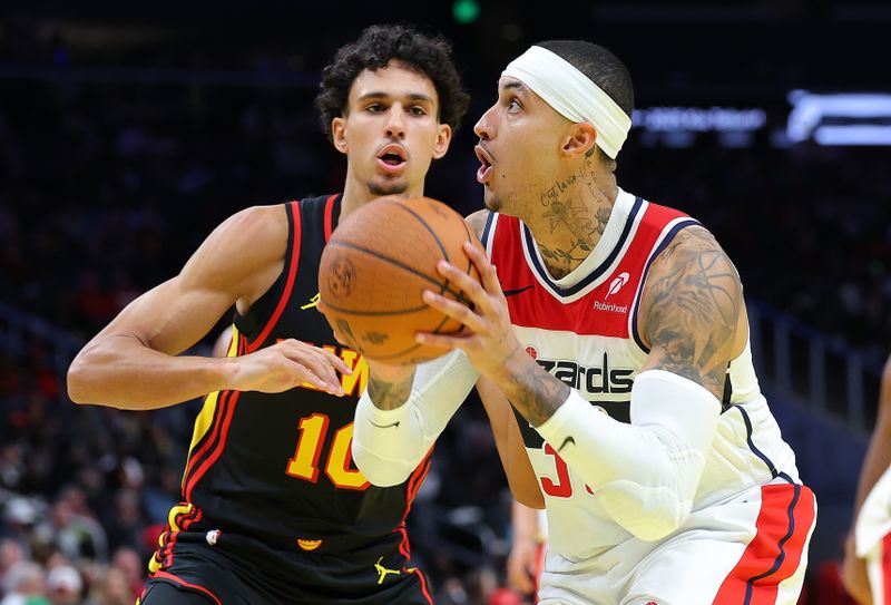 ATLANTA, GEORGIA - NOVEMBER 15:  Kyle Kuzma #33 of the Washington Wizards drives against Zaccharie Risacher #10 of the Atlanta Hawks during the second quarter of the Emirates NBA Cup game at State Farm Arena on November 15, 2024 in Atlanta, Georgia.  NOTE TO USER: User expressly acknowledges and agrees that, by downloading and/or using this photograph, user is consenting to the terms and conditions of the Getty Images License Agreement.  (Photo by Kevin C. Cox/Getty Images)