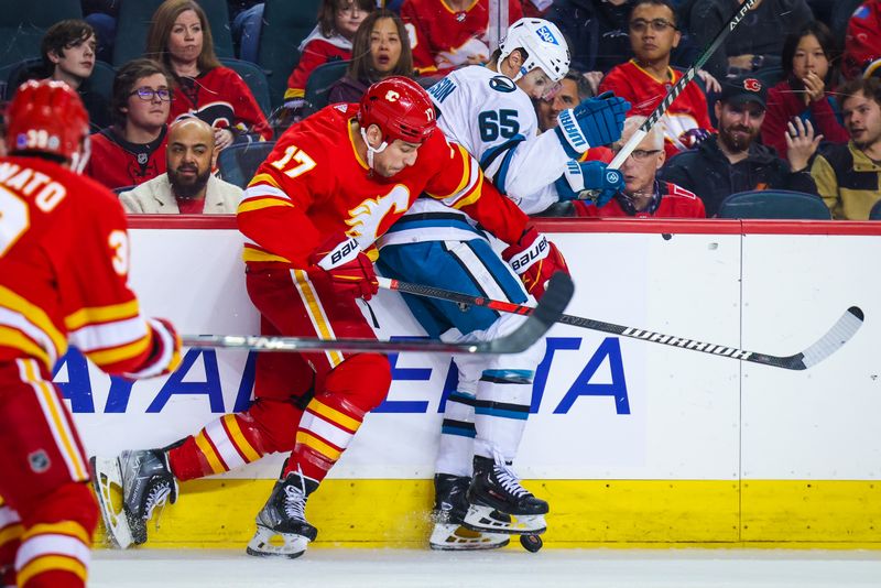 Apr 12, 2023; Calgary, Alberta, CAN; Calgary Flames left wing Milan Lucic (17) and San Jose Sharks defenseman Erik Karlsson (65) battle for the puck during the first period at Scotiabank Saddledome. Mandatory Credit: Sergei Belski-USA TODAY Sports