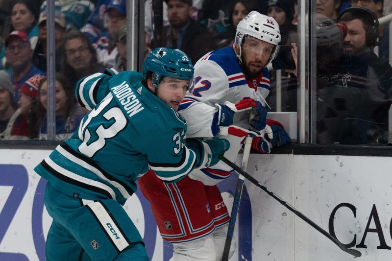 Jan 23, 2024; San Jose, California, USA; San Jose Sharks defenseman Calen Addison (33) and New York Rangers center Nick Bonino (12) watches the puck after colliding into the wall during the first period at SAP Center at San Jose. Mandatory Credit: Stan Szeto-USA TODAY Sports