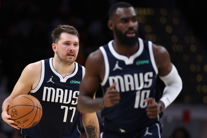 WASHINGTON, DC - NOVEMBER 15: Luka Doncic #77 of the Dallas Mavericks dribbles the ball behind of teammate Tim Hardaway Jr. #10 against the Washington Wizards during the first half at Capital One Arena on November 15, 2023 in Washington, DC. NOTE TO USER: User expressly acknowledges and agrees that, by downloading and or using this photograph, User is consenting to the terms and conditions of the Getty Images License Agreement. (Photo by Patrick Smith/Getty Images)