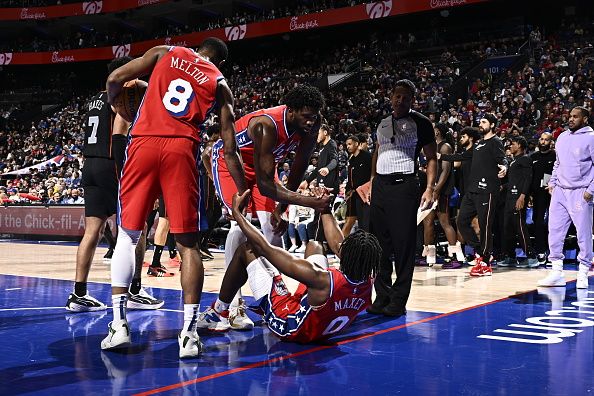 PHILADELPHIA, PA - DECEMBER 15: Joel Embiid #21 and De'Anthony Melton #8 help up Tyrese Maxey #0 of the Philadelphia 76ers during the game against the Detroit Pistons on December 15, 2023 at the Wells Fargo Center in Philadelphia, Pennsylvania NOTE TO USER: User expressly acknowledges and agrees that, by downloading and/or using this Photograph, user is consenting to the terms and conditions of the Getty Images License Agreement. Mandatory Copyright Notice: Copyright 2023 NBAE (Photo by David Dow/NBAE via Getty Images)