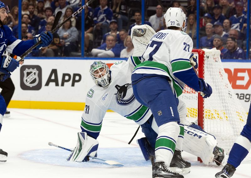 Oct 15, 2024; Tampa, Florida, USA; Vancouver Canucks goaltender Arturs Silovs (31) makes a save against the Tampa Bay Lightning during the first period at Amalie Arena. Mandatory Credit: Kim Klement Neitzel-Imagn Images