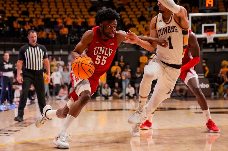 Feb 8, 2023; Laramie, Wyoming, USA; UNLV Runnin' Rebels guard EJ Harkless (55) drives against Wyoming Cowboys guard Brendan Wenzel (1) during the first half at Arena-Auditorium. Mandatory Credit: Troy Babbitt-USA TODAY Sports