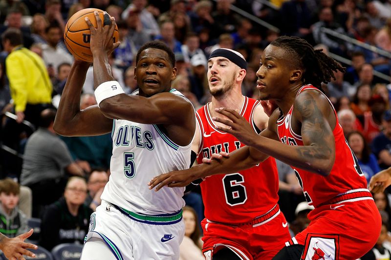 MINNEAPOLIS, MINNESOTA - MARCH 31: Anthony Edwards #5 of the Minnesota Timberwolves is double teamed by Ayo Dosunmu #12 and Alex Caruso #6 of the Chicago Bulls in the fourth quarter at Target Center on March 31, 2024 in Minneapolis, Minnesota. The Bulls defeated the Timberwolves 109-101. NOTE TO USER: User expressly acknowledges and agrees that, by downloading and or using this photograph, User is consenting to the terms and conditions of the Getty Images License Agreement. (Photo by David Berding/Getty Images)