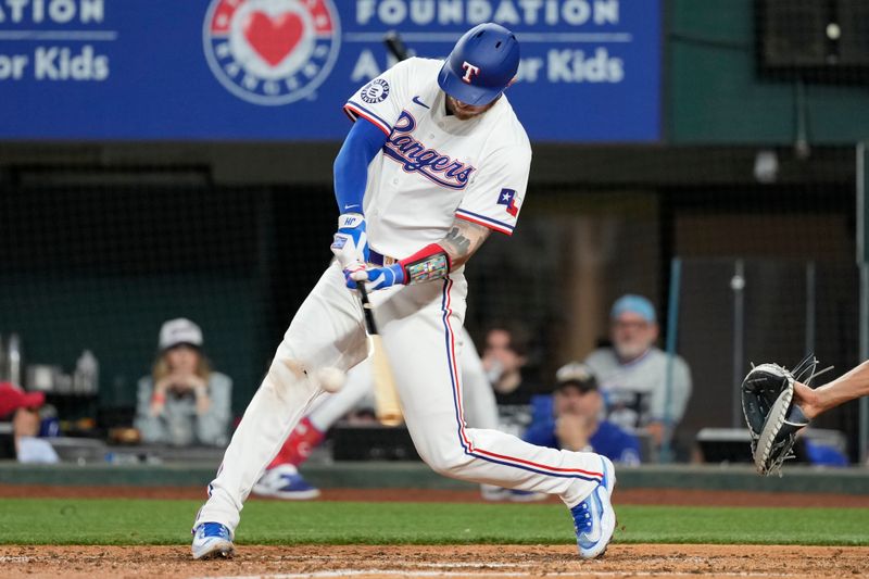 Apr 24, 2024; Arlington, Texas, USA; Texas Rangers catcher Jonah Heim (28) hits a single against the Seattle Mariners during the fourth inning at Globe Life Field. Mandatory Credit: Jim Cowsert-USA TODAY Sports