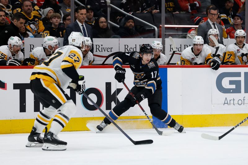 Jan 18, 2025; Washington, District of Columbia, USA; Washington Capitals center Dylan Strome (17) skates with the puckas Pittsburgh Penguins defenseman Ryan Graves (27) defends in the third period at Capital One Arena. Mandatory Credit: Geoff Burke-Imagn Images