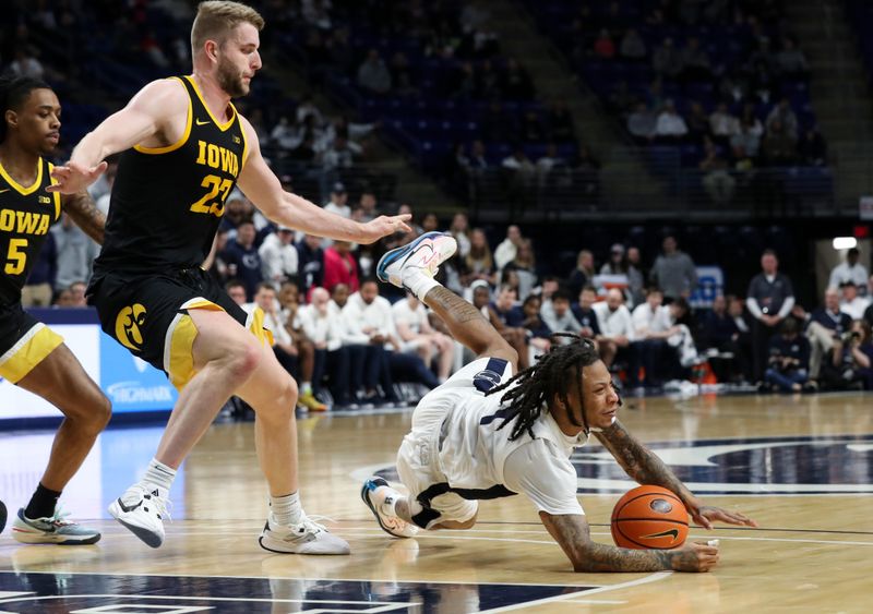 Feb 8, 2024; University Park, Pennsylvania, USA; Penn State Nittany Lions guard Ace Baldwin Jr (1) looses his footing while dribbling the ball around Iowa Hawkeyes forward Ben Krikke (23) during the first half at Bryce Jordan Center. Mandatory Credit: Matthew O'Haren-USA TODAY Sports