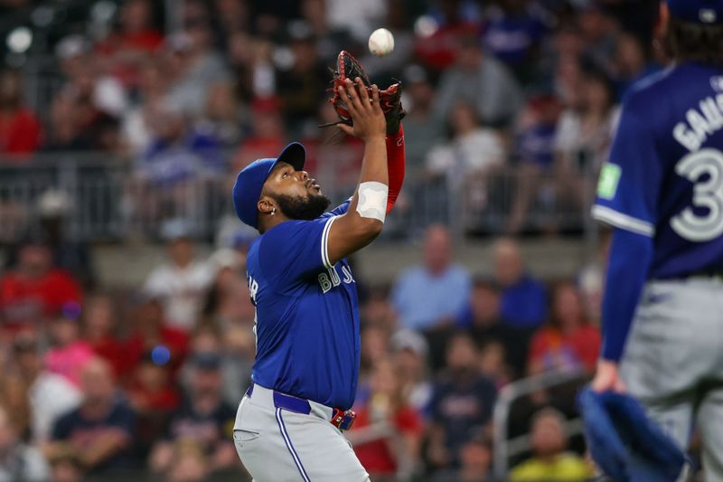 Sep 6, 2024; Atlanta, Georgia, USA; Toronto Blue Jays first baseman Vladimir Guerrero Jr. (27) catches a pop fly against the Atlanta Braves in the fourth inning at Truist Park. Mandatory Credit: Brett Davis-Imagn Images