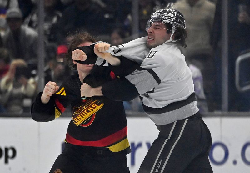 Apr 10, 2023; Los Angeles, California, USA;  Vancouver Canucks center Sheldon Dries (15) and Los Angeles Kings defenseman Sean Durzi (50) fight in the second period at Crypto.com Arena. Mandatory Credit: Jayne Kamin-Oncea-USA TODAY Sports