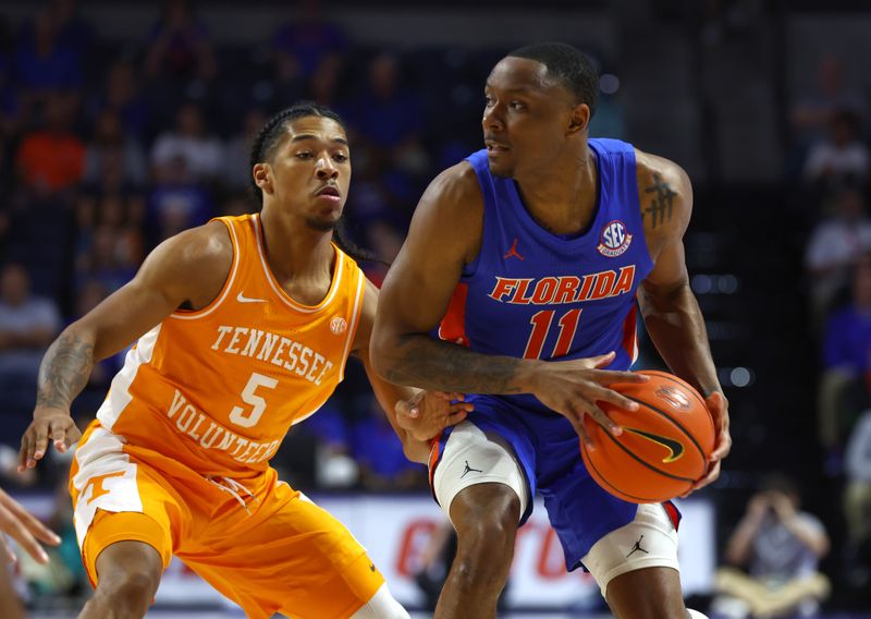 Feb 1, 2023; Gainesville, Florida, USA; Florida Gators guard Kyle Lofton (11) looks to pass against Tennessee Volunteers guard Zakai Zeigler (5) defends during the first half at Exactech Arena at the Stephen C. O'Connell Center. Mandatory Credit: Kim Klement-USA TODAY Sports