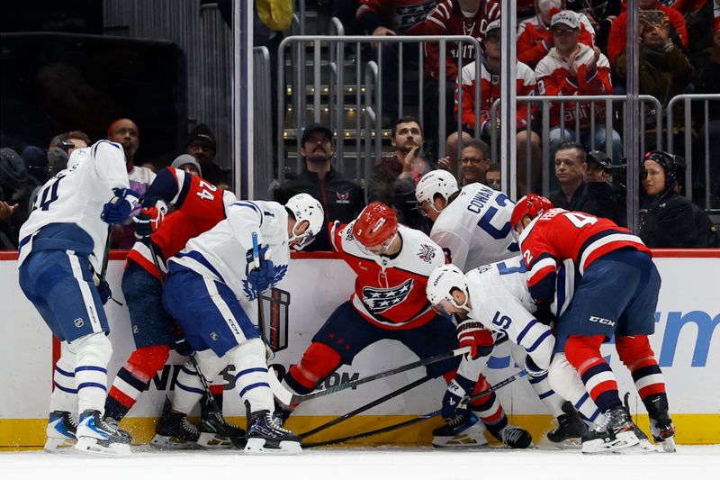 Nov 28, 2025; Washington, District of Columbia, USA; Toronto Maple Leafs and Washington Capitals players battle for the puck during the final minute during the third period at Capital One Arena. Mandatory Credit: Geoff Burke-Imagn Images