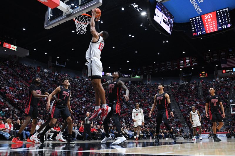 Jan 6, 2024; San Diego, California, USA; San Diego State Aztecs forward Jaedon LeDee (13) dunks the ball as UNLV Rebels forward Jalen Hill (1) looks on during the first half at Viejas Arena. Mandatory Credit: Orlando Ramirez-USA TODAY Sports