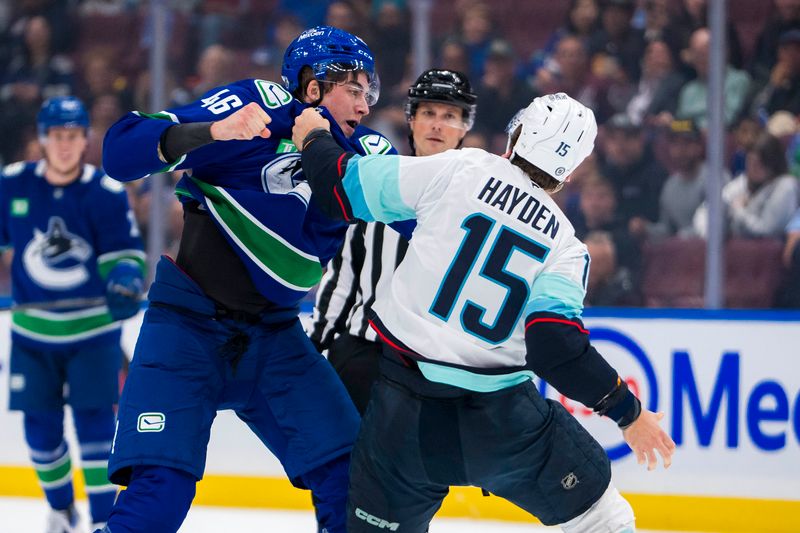 Sep 24, 2024; Vancouver, British Columbia, CAN; Seattle Kraken forward Brandon Biro (15) fights with Vancouver Canucks forward Vilmer Alriksson (46) during the first period at Rogers Arena. Mandatory Credit: Bob Frid-Imagn Images