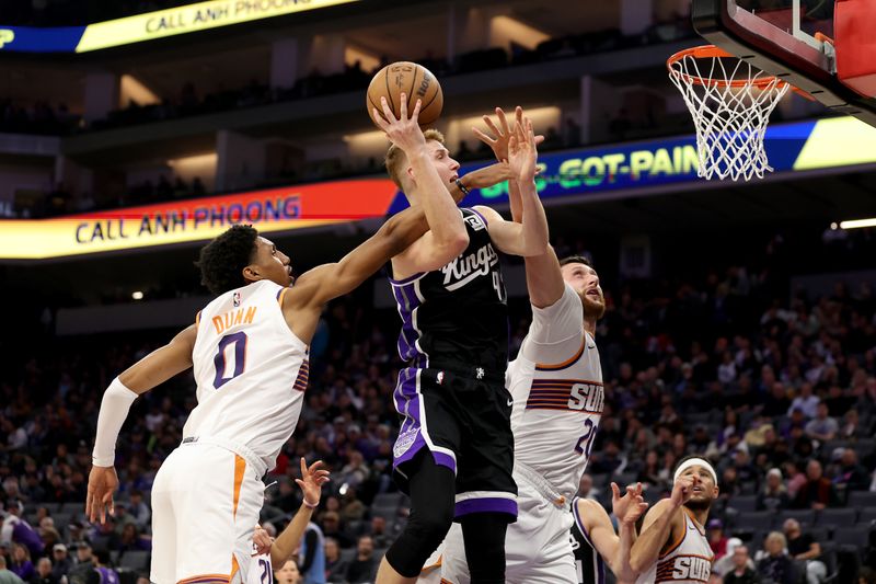 SACRAMENTO, CALIFORNIA - NOVEMBER 13: Kevin Huerter #9 of the Sacramento Kings goes up for a shot on Ryan Dunn #0 and Jusuf Nurkic #20 of the Phoenix Suns in the second half at Golden 1 Center on November 13, 2024 in Sacramento, California. NOTE TO USER: User expressly acknowledges and agrees that, by downloading and/or using this photograph, user is consenting to the terms and conditions of the Getty Images License Agreement.  (Photo by Ezra Shaw/Getty Images)