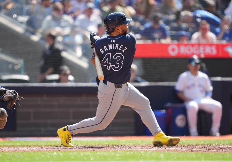 May 18, 2024; Toronto, Ontario, CAN; Tampa Bay Rays designated hitter Harold Ramírez (43) hits single against the against the Toronto Blue Jays during the sixth inning at Rogers Centre. Mandatory Credit: Nick Turchiaro-USA TODAY Sports