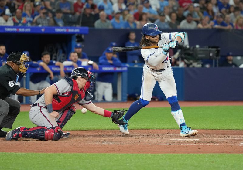 May 12, 2023; Toronto, Ontario, CAN; Toronto Blue Jays shortstop Bo Bichette (11) gets a wild pitch scoring a run against the Atlanta Braves during the seventh inning at Rogers Centre. Mandatory Credit: Nick Turchiaro-USA TODAY Sports