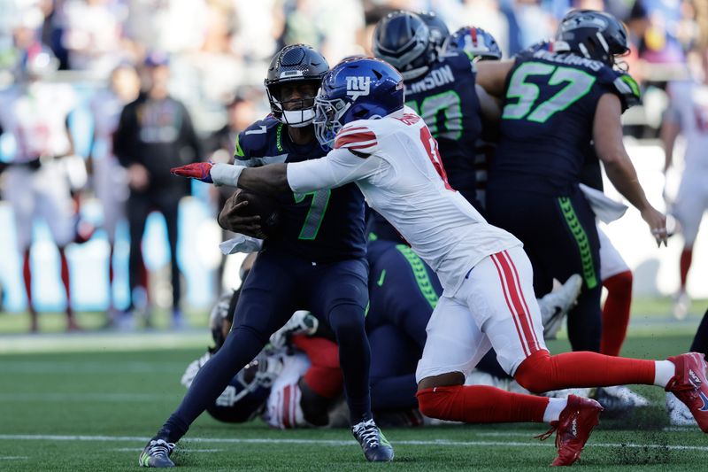 Seattle Seahawks quarterback Geno Smith (7) is sacked by New York Giants linebacker Brian Burns (0) during the second half of an NFL football game, Sunday, Oct. 6, 2024, in Seattle. (AP Photo/John Froschauer)