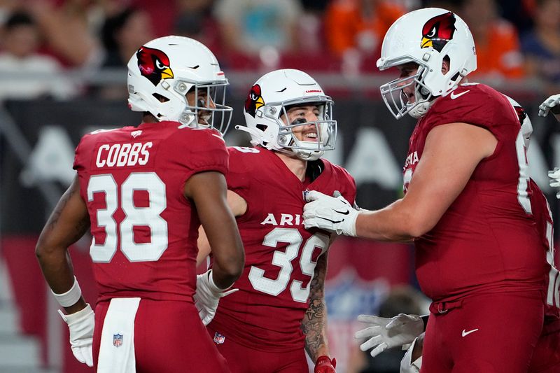 Arizona Cardinals wide receiver Kaden Davis, middle, is congratulated by wide receiver Brian Cobbs (38) and offensive tackle Jackson Barton after scoring against the Denver Broncos during the second half of an NFL preseason football game in Glendale, Ariz., Friday, Aug. 11, 2023. (AP Photo/Matt York)