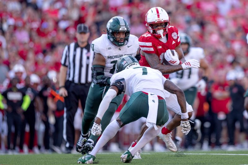 Oct 4, 2025; Lincoln, Nebraska, USA; Michigan State Spartans defensive back Joshua Eaton (7) defends Nebraska Cornhuskers wide receiver Nyziah Hunter (13) at Memorial Stadium. Mandatory Credit: Kylie Graham-Imagn Images